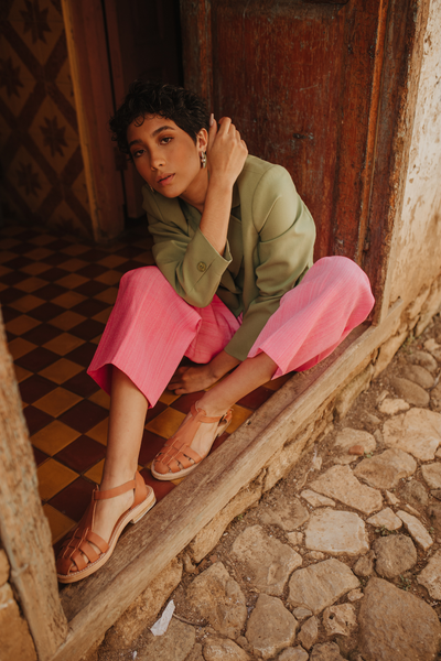 Model crouching on floor wearing Carmela fisherman sandal handmade in Mexico 